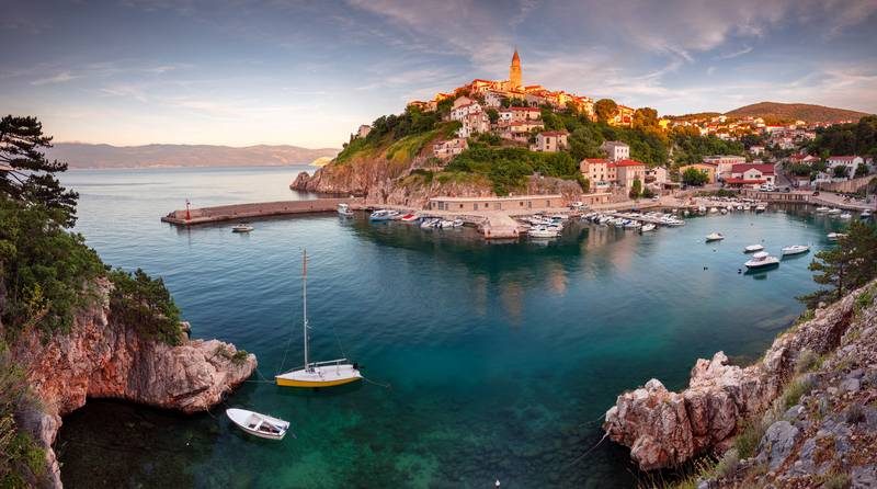 Port pittoresque avec maisons sur une colline.