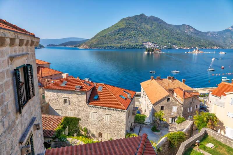 Vue panoramique sur la baie de Kotor depuis les toits en pierre de la vieille ville, avec les montagnes du Monténégro en arrière-plan