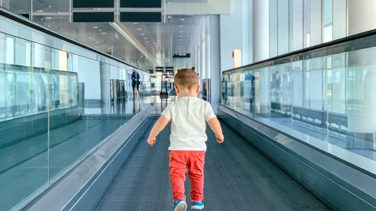 Enfant marchant dans le couloir d’un aéroport avant un voyage en famille