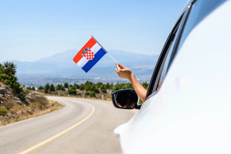 Une main tenant un drapeau croate sortant d