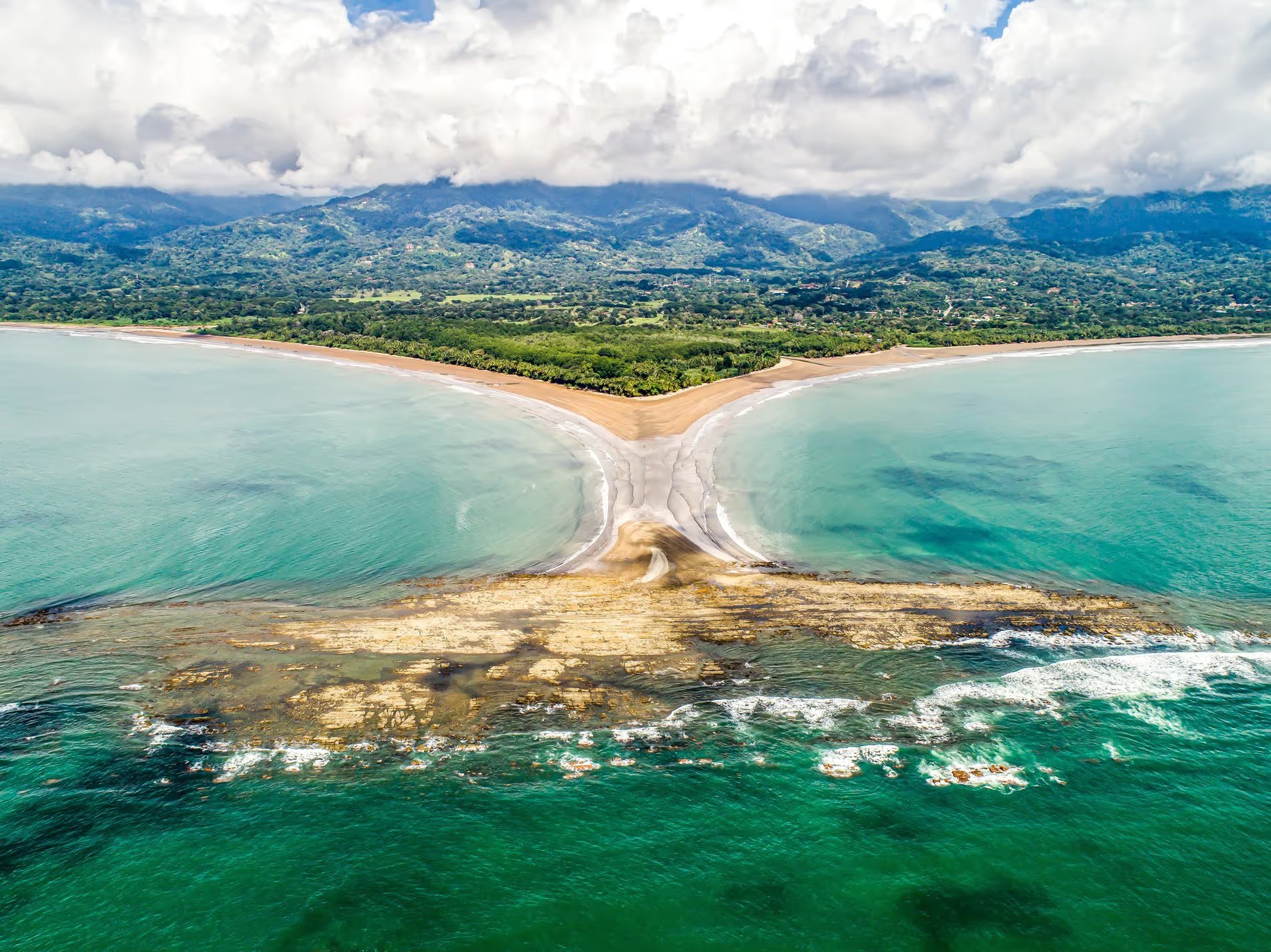Vue aérienne spectaculaire de la formation naturelle en forme de queue de baleine sur la plage d'Uvita, Costa Rica, entourée par l'océan turquoise et la forêt tropicale luxuriante.