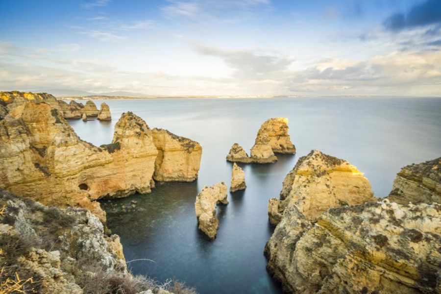 Les impressionnantes falaises de Ponta da Piedade à Lagos, Portugal, illuminées par la lumière du coucher de soleil.