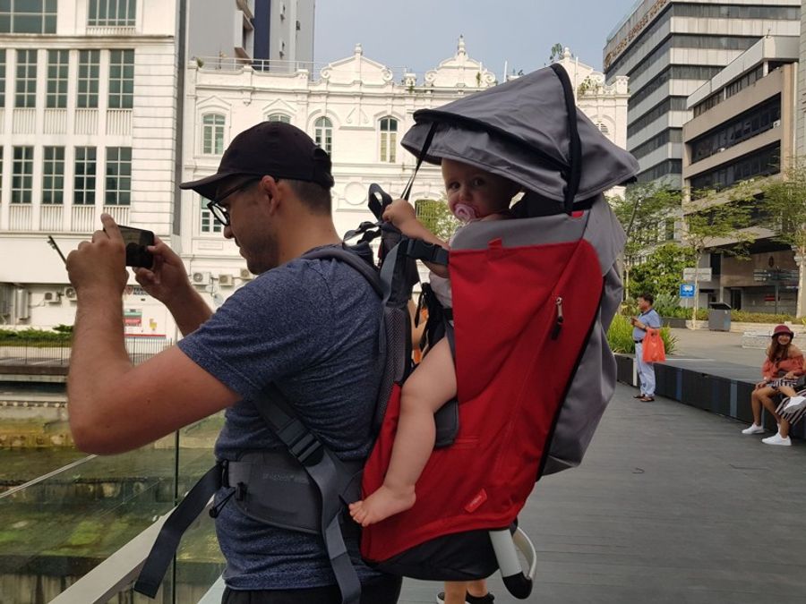 Parent portant un bébé dans un porte-bébé de randonnée à Kuala Lumpur, parfait pour visiter la ville avec un jeune enfant