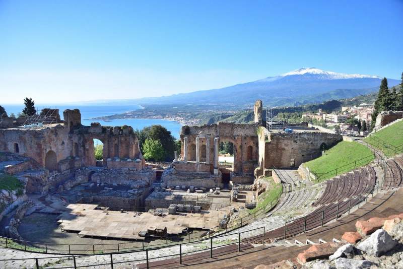 Vue du Théâtre grec de Taormine avec l'Etna en arrière-plan, surplombant la mer Ionienne en Sicile.