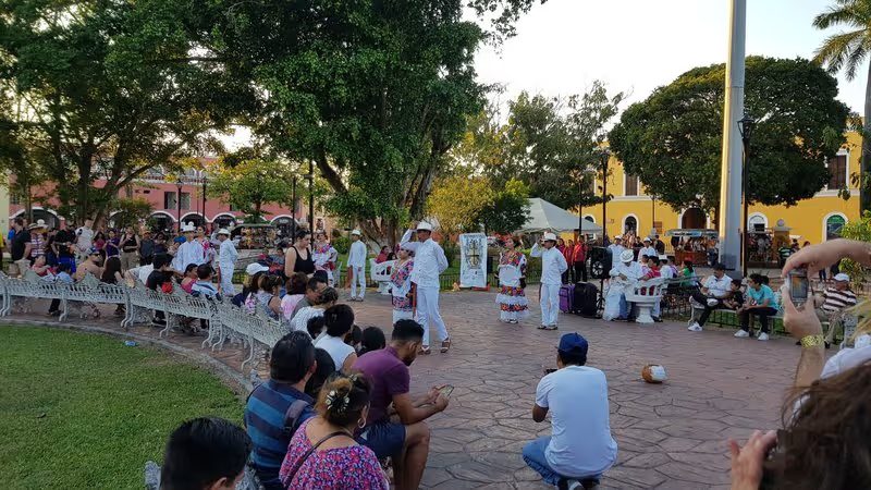 Spectacle de danse traditionnelle sur une place publique à Valladolid, avec des danseurs en costumes colorés et une foule de spectateurs.