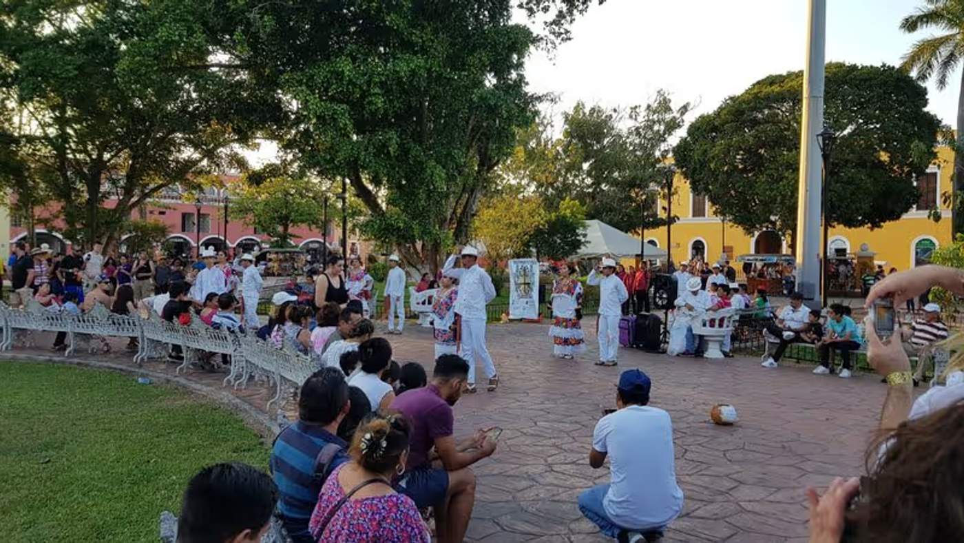 Spectacle de danse traditionnelle sur une place publique à Valladolid, avec des danseurs en costumes colorés et une foule de spectateurs.