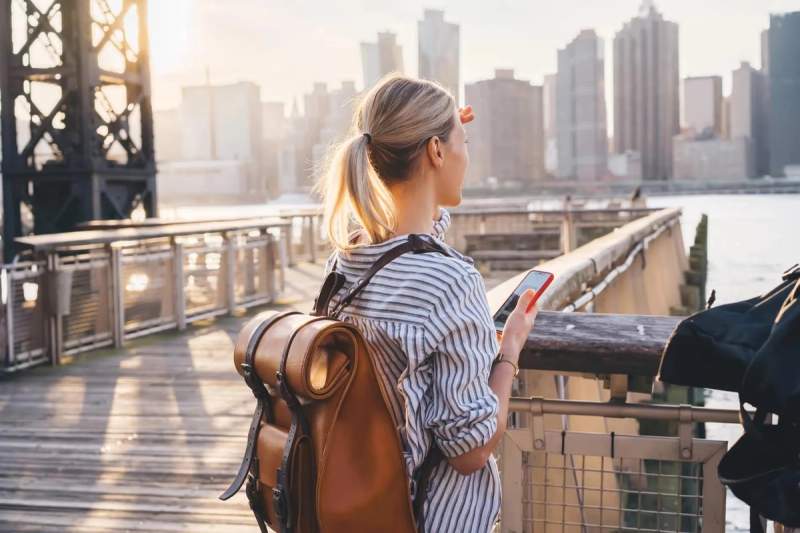 Personne regardant la vue sur la ville avec un smartphone, utilisant une eSIM aux États-Unis.