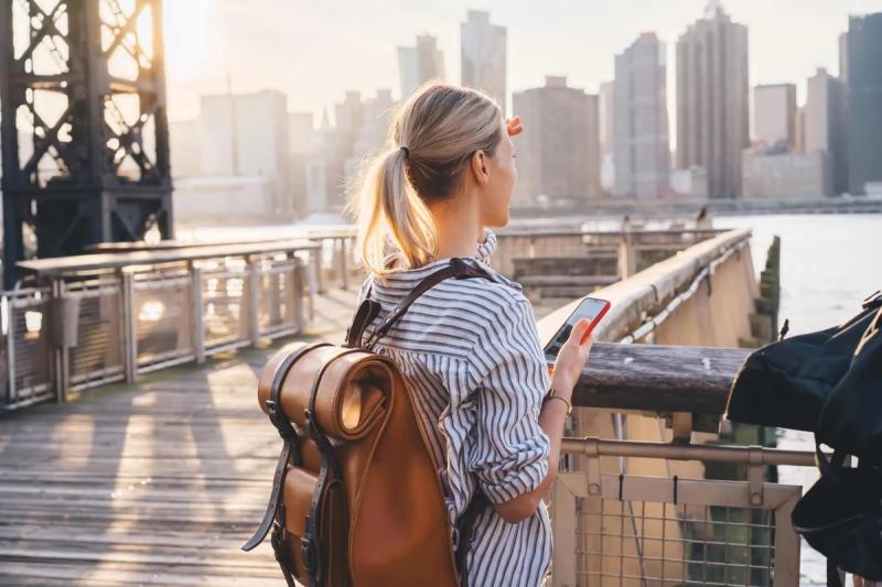Personne regardant la vue sur la ville avec un smartphone, utilisant une eSIM aux États-Unis.