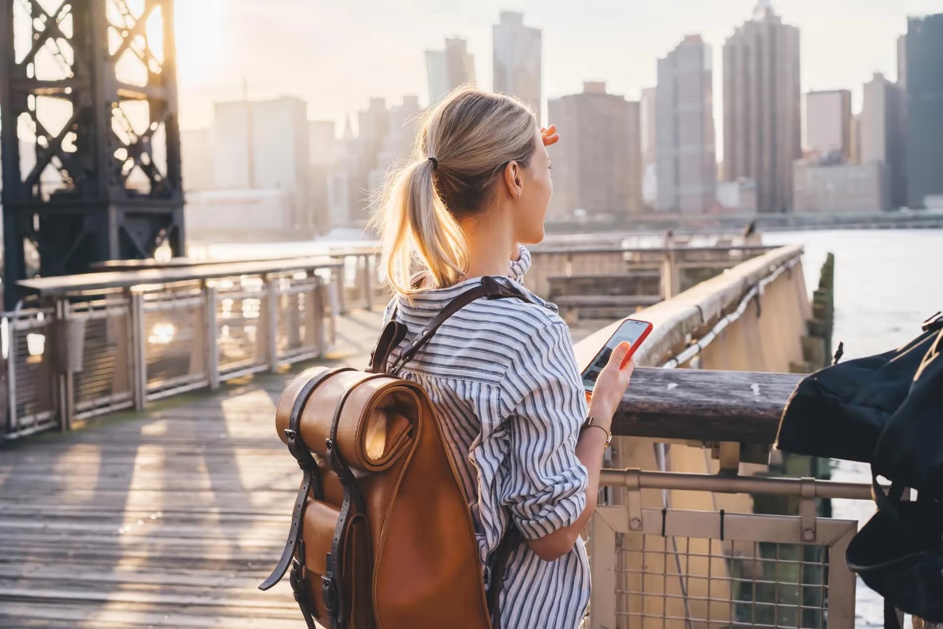 Personne regardant la vue sur la ville avec un smartphone, utilisant une eSIM aux États-Unis.