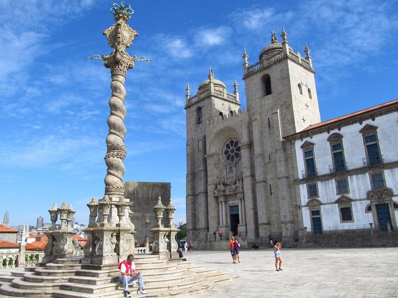 Place de la cathédrale Sé de Braga, Portugal, avec des éléments architecturaux gothiques et une colonne sculptée.