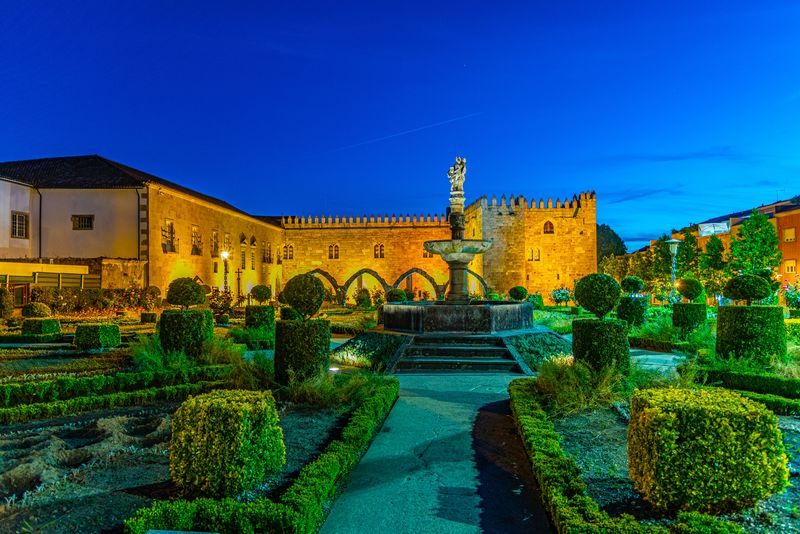Jardin de Santa Barbara illuminé de nuit, mettant en valeur ses arbustes bien taillés et sa fontaine centrale.