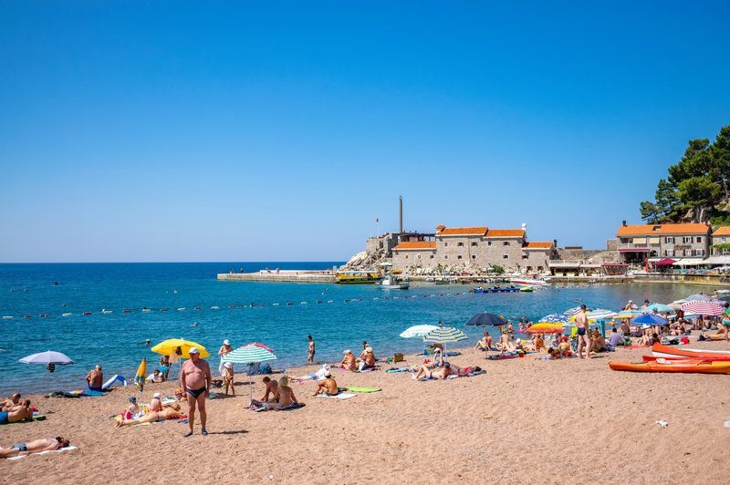 Plage de Mogren à Budva avec la vieille ville en arrière-plan et mer Adriatique