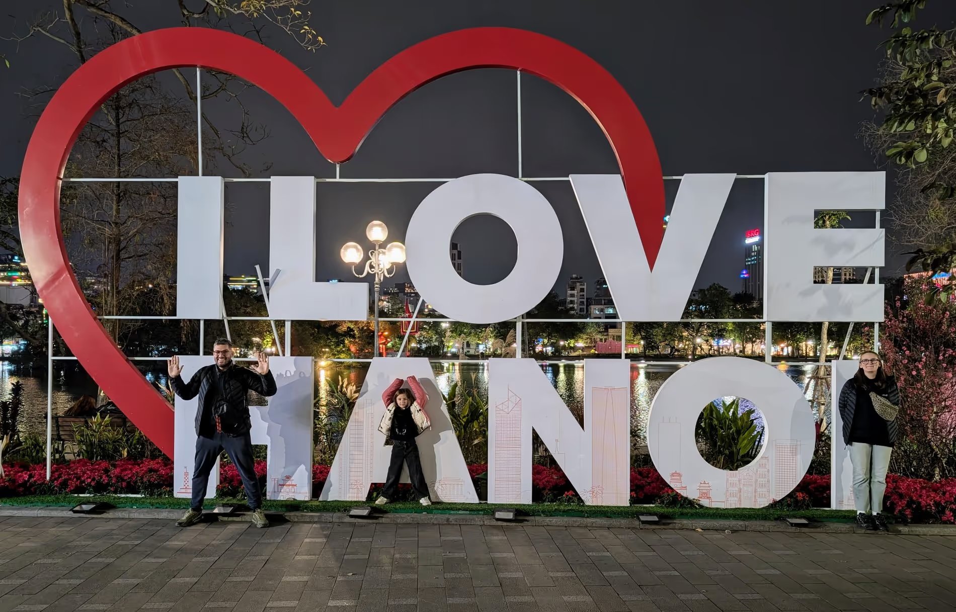 Nous posant devant l’installation lumineuse "I LOVE HANOI" au bord du lac Hoan Kiem, en soirée à Hanoï.