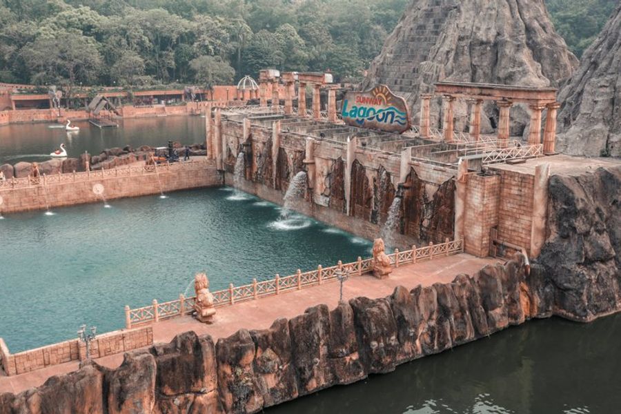 Vue panoramique du parc aquatique Sunway Lagoon avec des cascades et des sculptures.