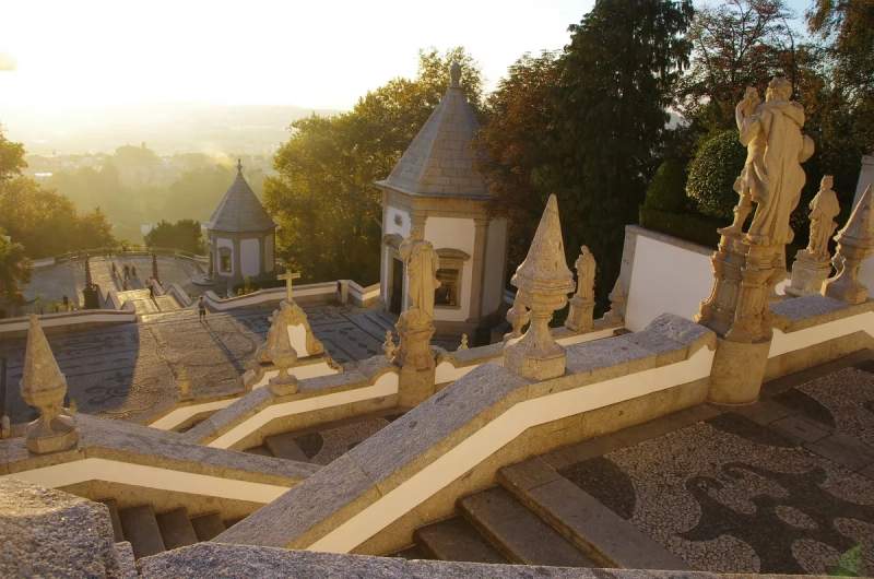 Vue du coucher de soleil au Sanctuaire du Bom Jesus do Monte à Braga, Portugal, avec ses escaliers ornés et ses statues en pierre.