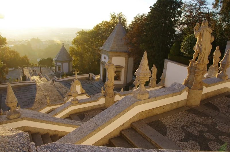 Vue du coucher de soleil au Sanctuaire du Bom Jesus do Monte à Braga, Portugal, avec ses escaliers ornés et ses statues en pierre.