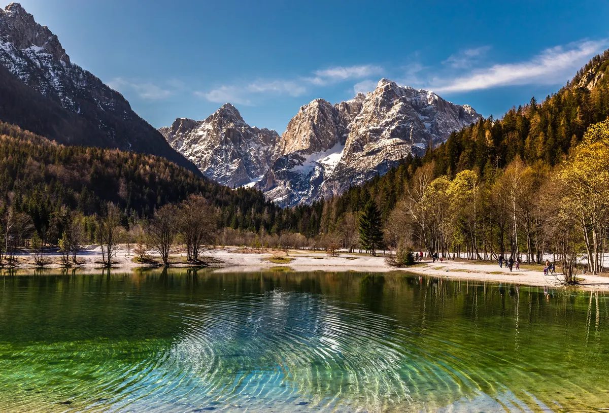 Lac Jasna aux eaux turquoise cristallines face aux sommets enneigés des Alpes juliennes dans le parc national du Triglav, Slovénie