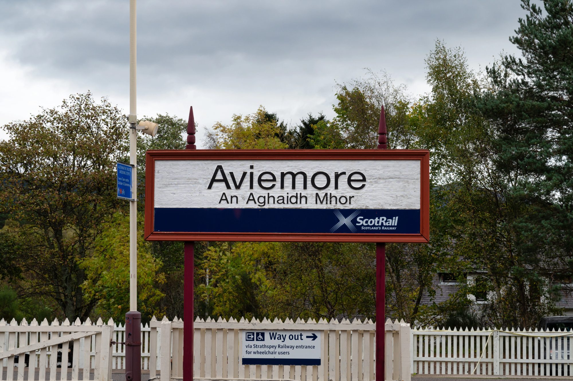 Le panneau de la gare d’Aviemore porte le nom de la ville en anglais et en gaélique, au-dessus du logo ScotRail et d’une clôture blanche