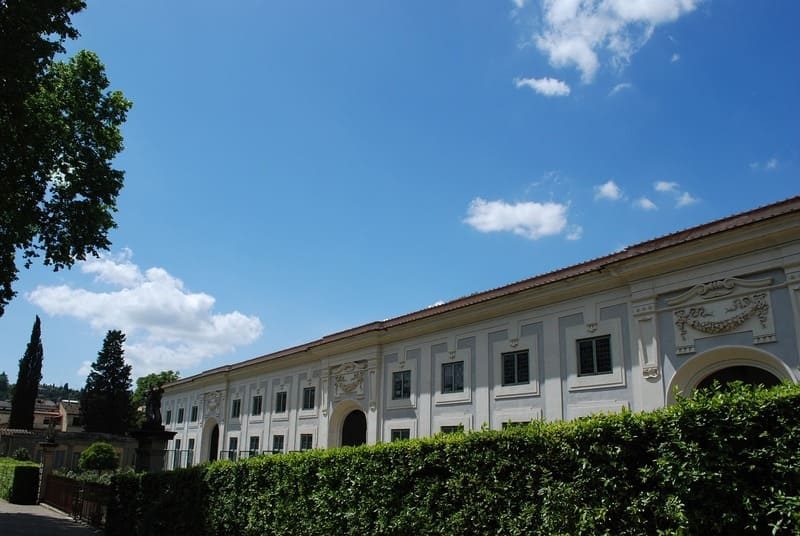 Une vue dégagée des Jardins de Boboli à Florence, montrant une allée bordée de haies et de statues.