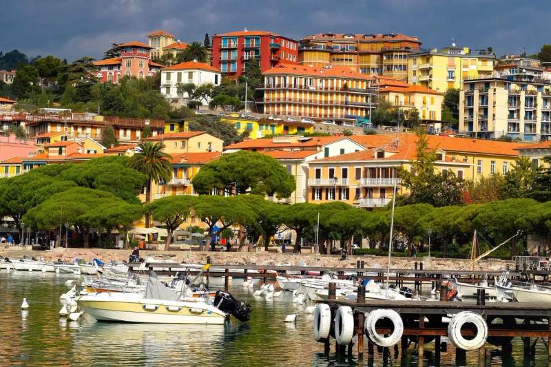 Vue sur les bâtiments colorés de Lerici, Italie, avec des bateaux amarrés au premier plan.