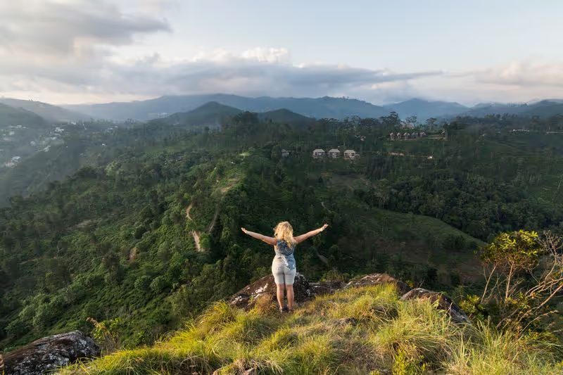 Une femme profitant d'une vue panoramique sur les montagnes verdoyantes près d'Ella au Sri Lanka.