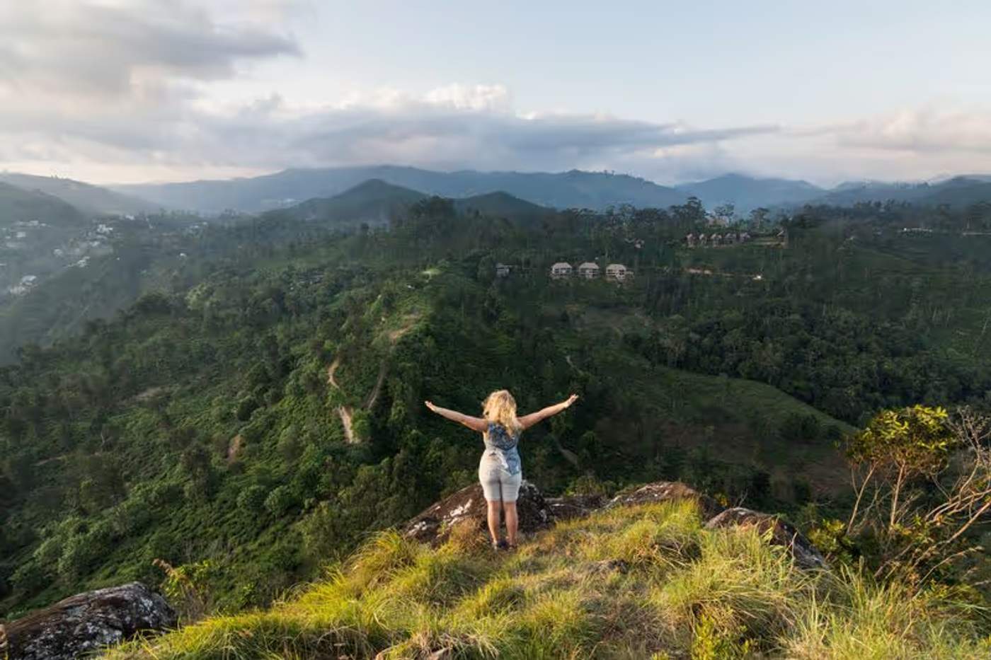 Une femme profitant d'une vue panoramique sur les montagnes verdoyantes près d'Ella au Sri Lanka.