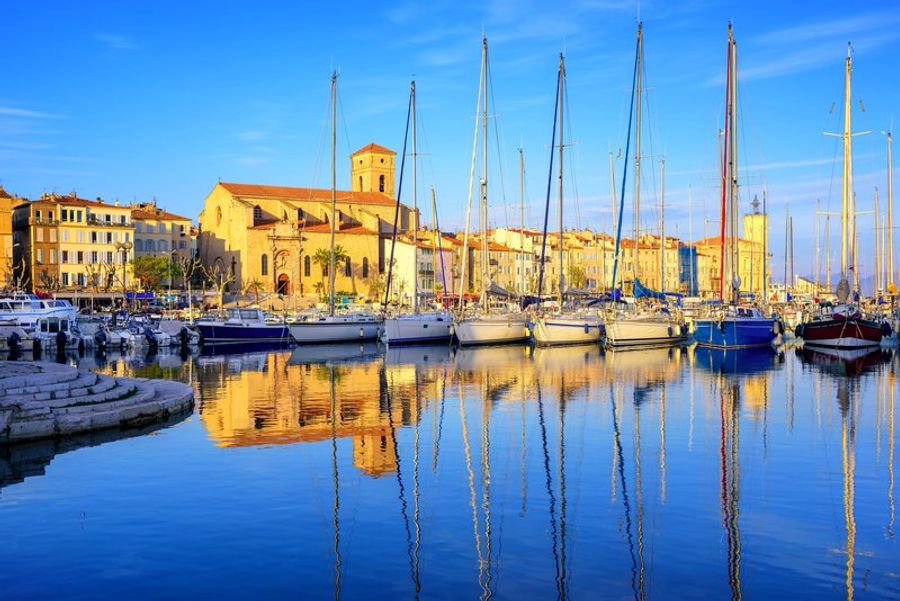 Le vieux port de La Ciotat avec des bateaux traditionnels amarrés sous un ciel bleu clair.