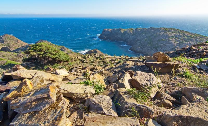 Une vue sur les falaises et la mer du Parc Naturel du Cap de Creus, avec des formations rocheuses accidentées.
