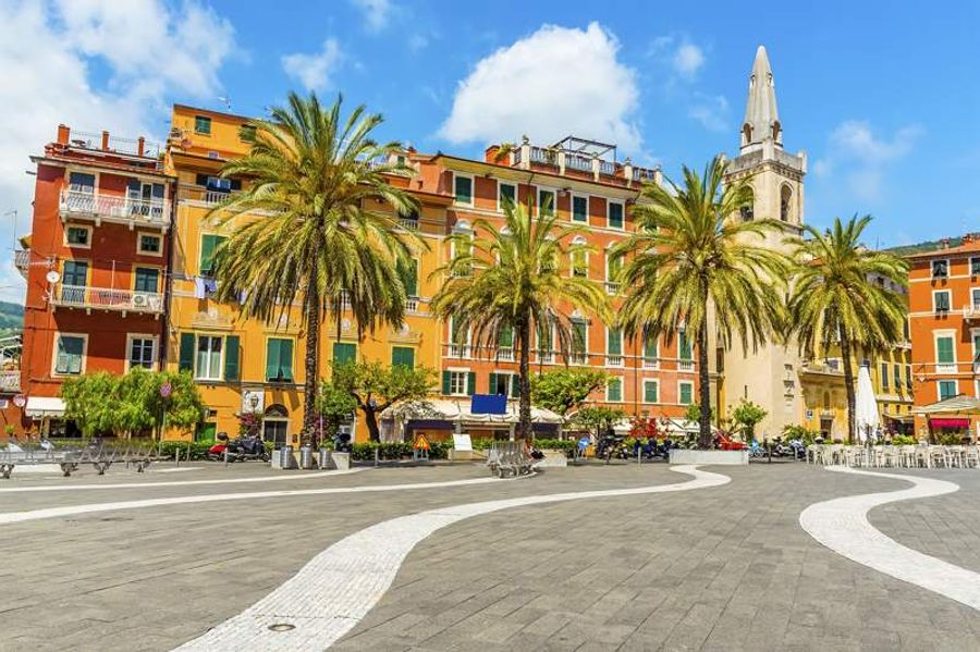 Place animée de Piazza Garibaldi à Lerici, bordée de palmiers et de bâtiments colorés.
