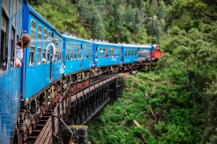 Train bleu traversant un pont en bois sur la ligne panoramique entre Kandy et Ella.