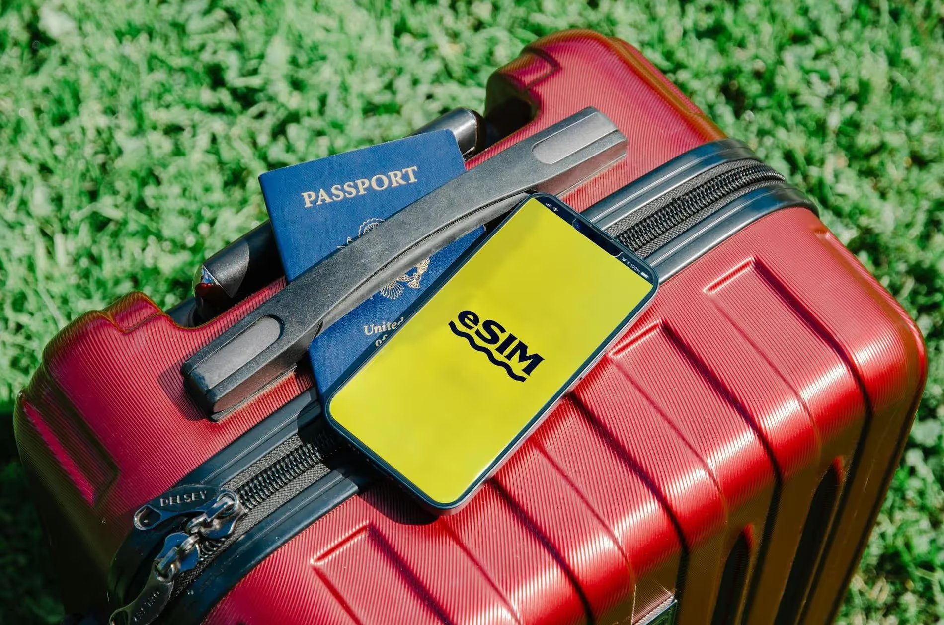 Valise rouge avec passeport et téléphone affichant 'eSIM', prêt pour le voyage.