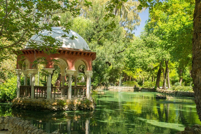 Petit pavillon dans le parc María Luisa, entouré de verdure et situé au bord d