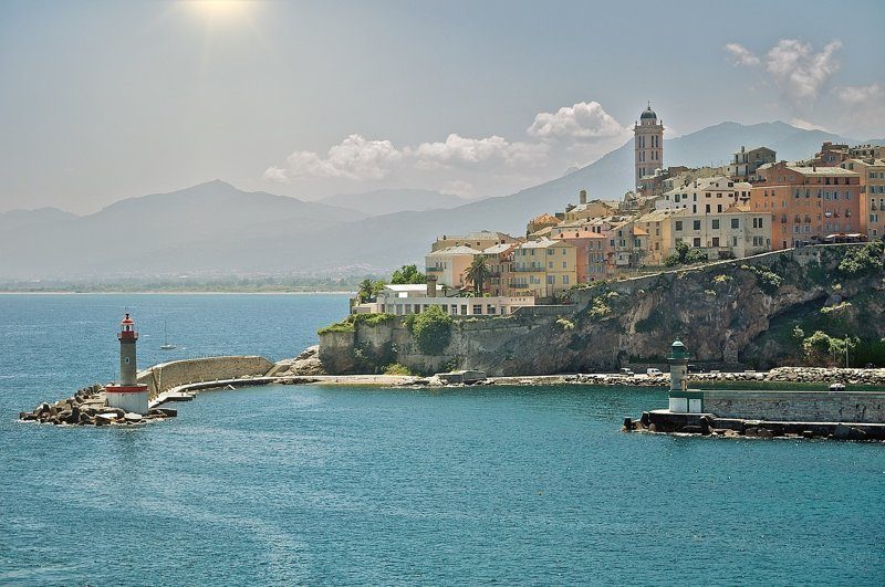 Vue sur le vieux port de Bastia avec ses maisons colorées et son église Saint-Jean-Baptiste.
