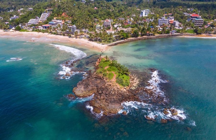 Vue aérienne de Parrot Rock à Mirissa, un petit îlot rocheux recouvert de végétation, entouré d