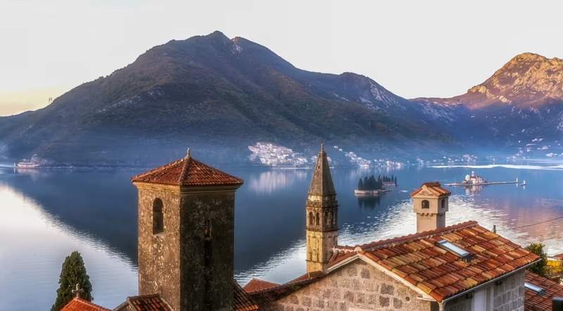 Vue sur les églises et toits de Perast avec les îlots Notre-Dame-du-Rocher et Saint-Georges dans la baie de Kotor au Monténégro.