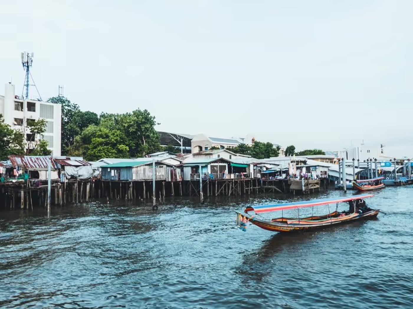 Bateaux sur la rivière avec des habitations en arrière-plan à Bangkok