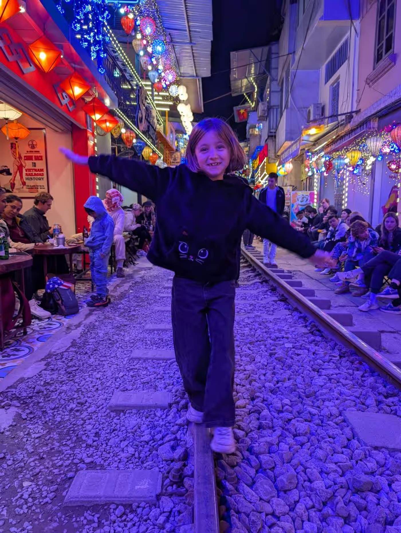 Anna marchant sur les rails illuminés de Hanoi Train Street