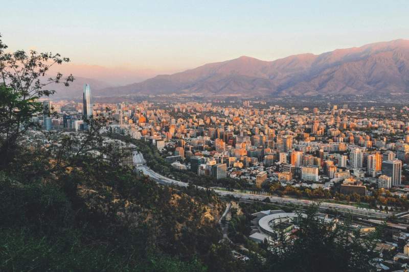 Vue panoramique de Santiago, la capitale du Chili, avec des gratte-ciels modernes se dressant contre le cadre montagneux à l’horizon.