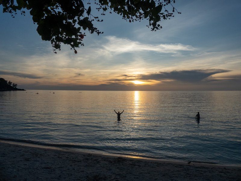 Un coucher de soleil avec deux personnes dans l