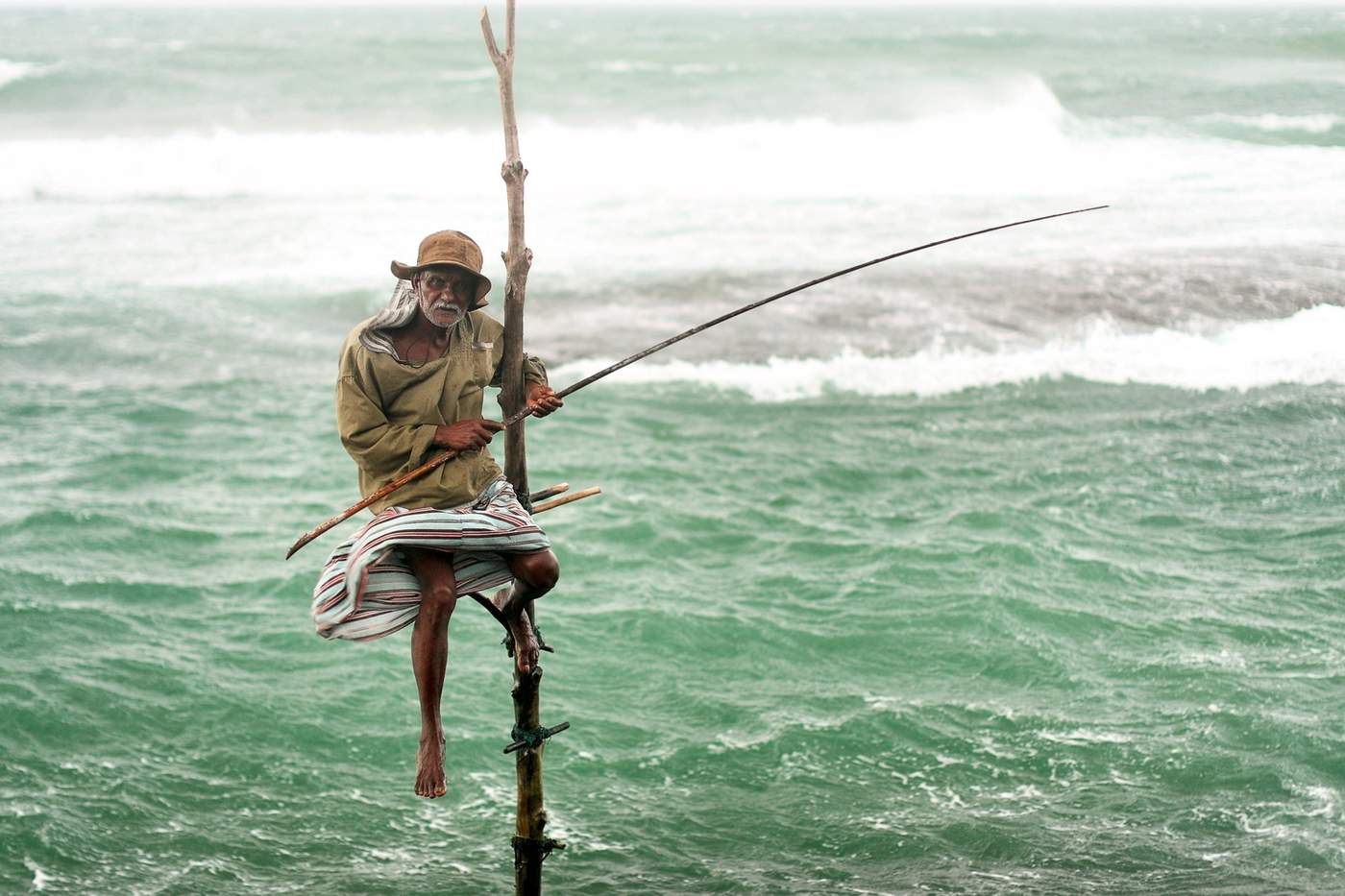 Pêcheur traditionnel sur piquet en bord de mer à Galle, Sri Lanka