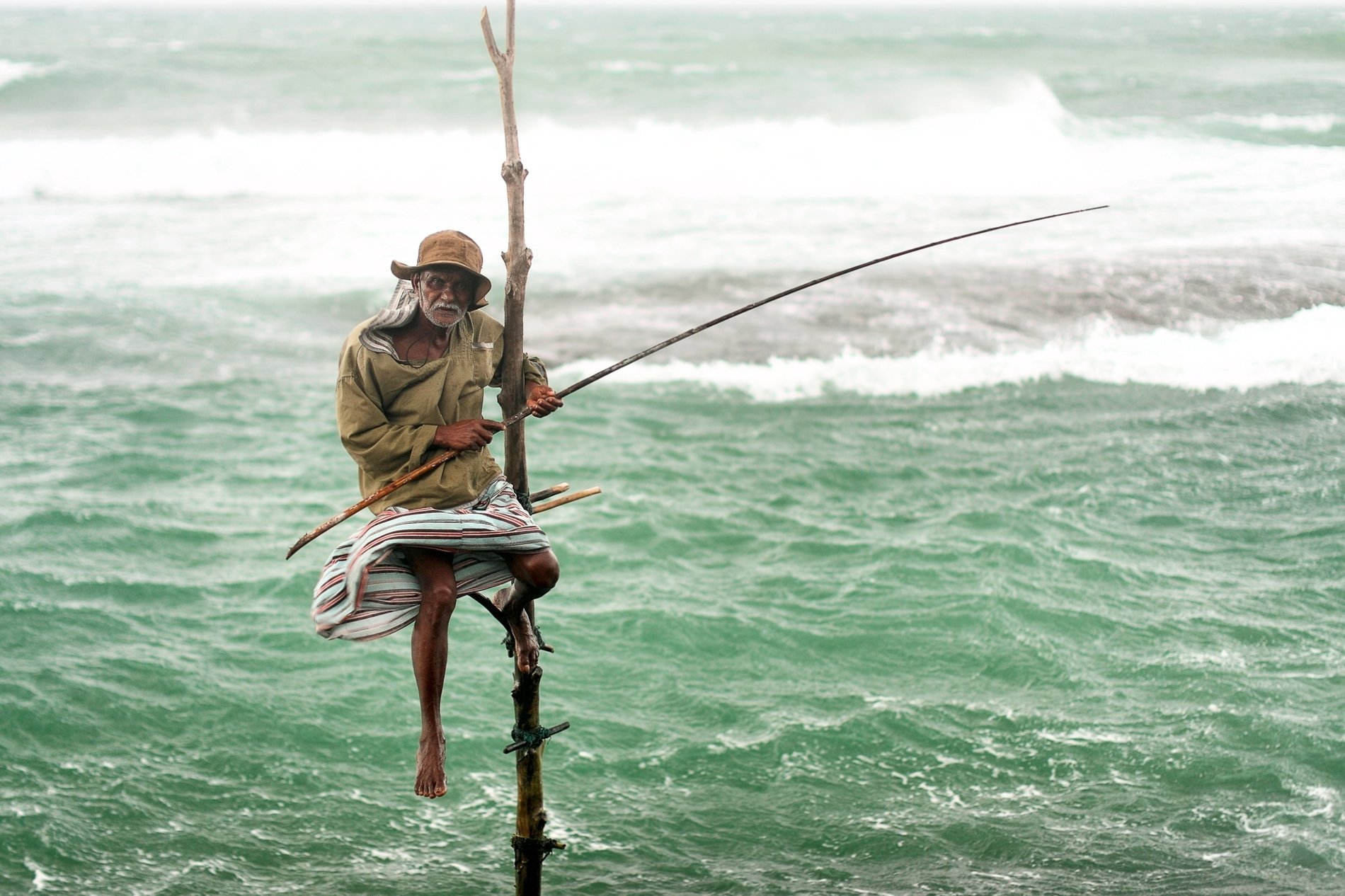 Pêcheur traditionnel sur piquet en bord de mer à Galle, Sri Lanka