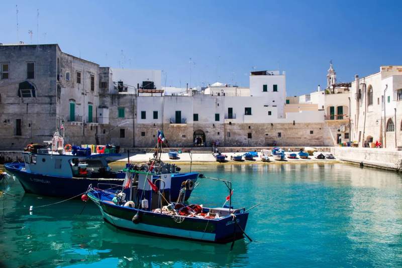 Vue du port de Monopoli, Italie, avec des bateaux de pêche colorés.