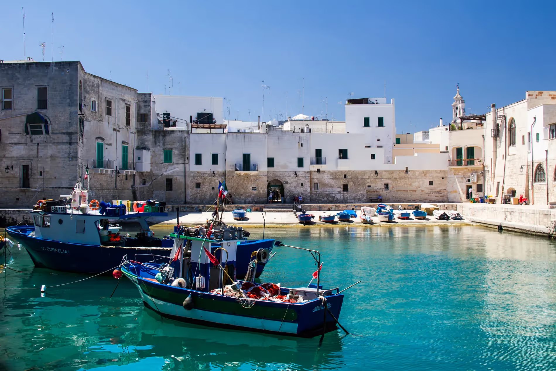 Vue du port de Monopoli, Italie, avec des bateaux de pêche colorés.