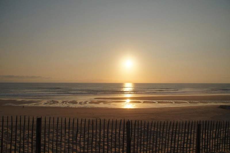 Coucher de soleil sur une plage de Biscarrosse, avec une vue dégagée sur l'océan Atlantique