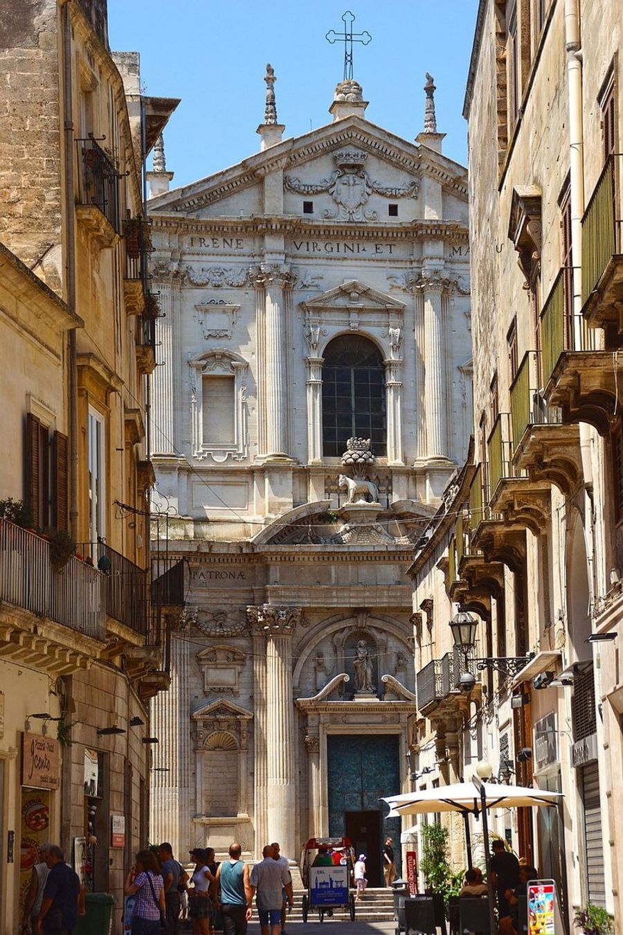 Rue animée de Lecce avec des bâtiments baroques et des passants.
