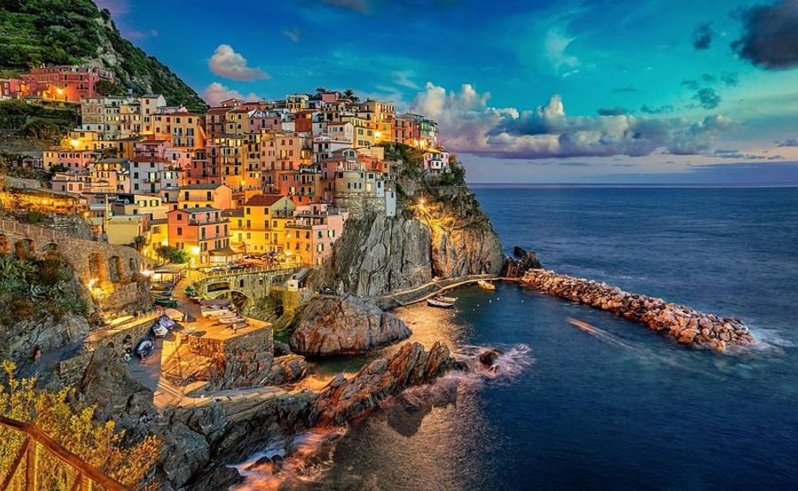 Vue pittoresque de Riomaggiore avec un magnifique coucher de soleil illuminant le village et la mer.