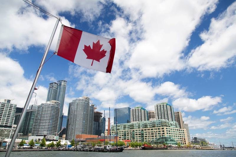 Drapeau canadien devant le skyline de Toronto depuis le lac Ontario — étape clé d