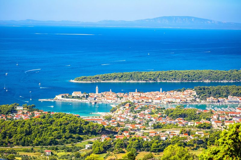 Vue aérienne de la vieille ville d'Rab et son archipel en Croatie, avec ses toits de tuiles orangées, ses clochers médiévaux et les eaux turquoise de l'Adriatique