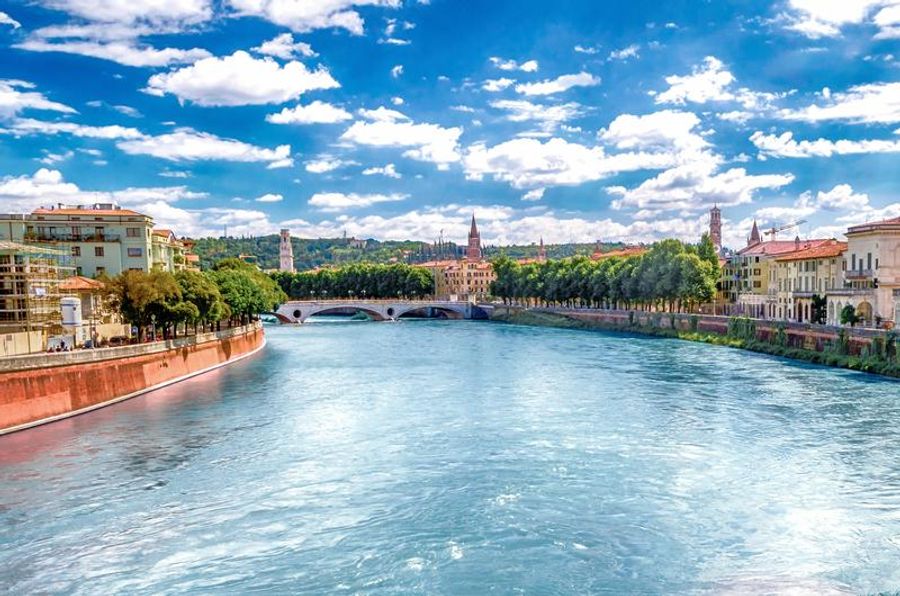 Vue panoramique du fleuve Adige traversant Vérone, entouré de bâtiments historiques.