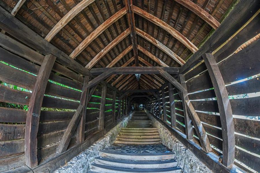Escaliers couverts en bois menant à une église ou un site historique.